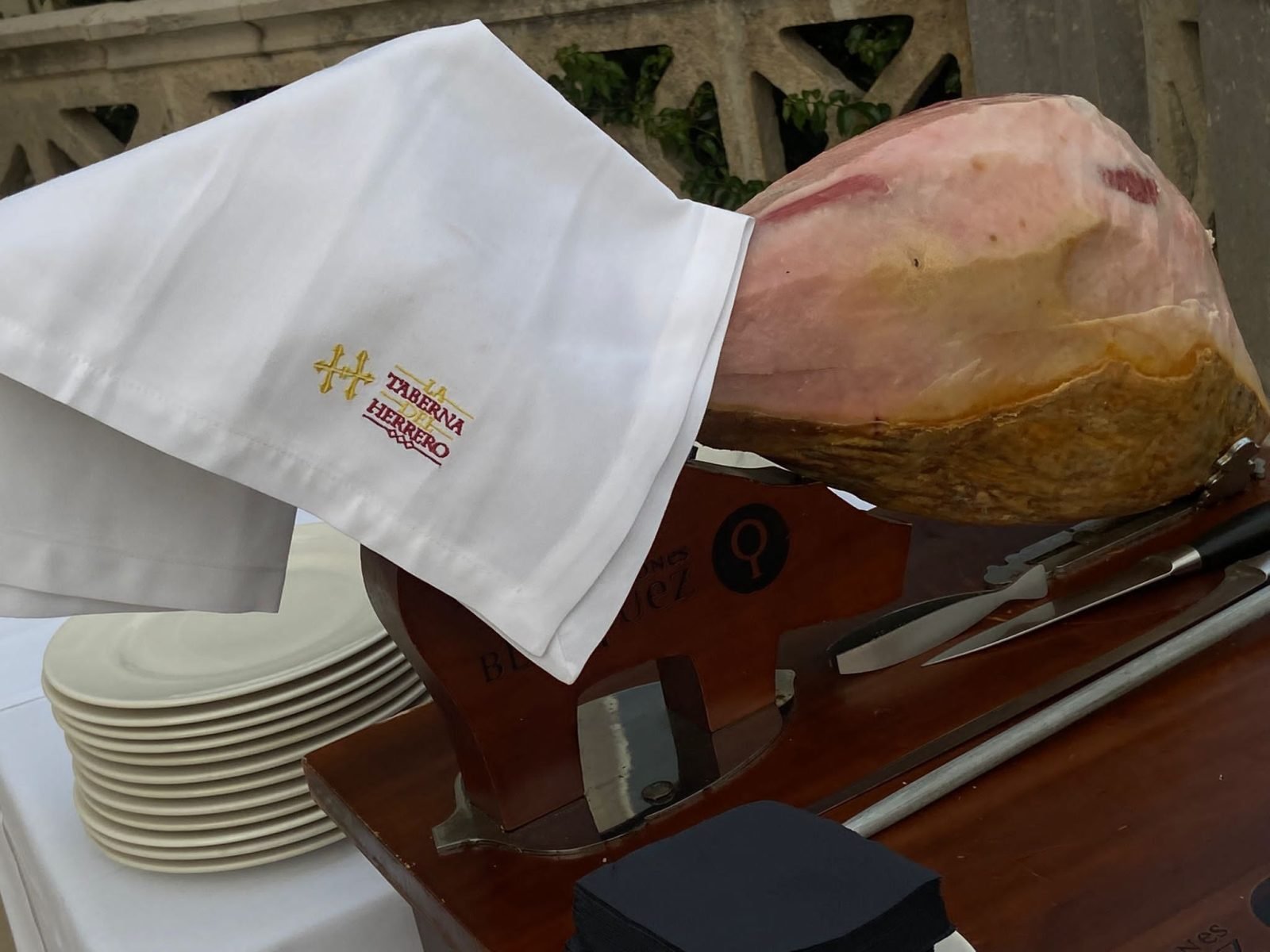 Jamón en soporte con servilleta bordada con el logo de La Taberna del Herrero