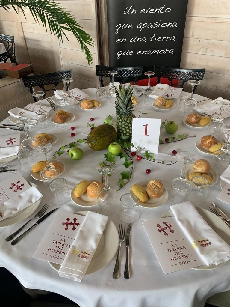 Mesa de evento con panes, frutas y minutas de La Taberna del Herrero