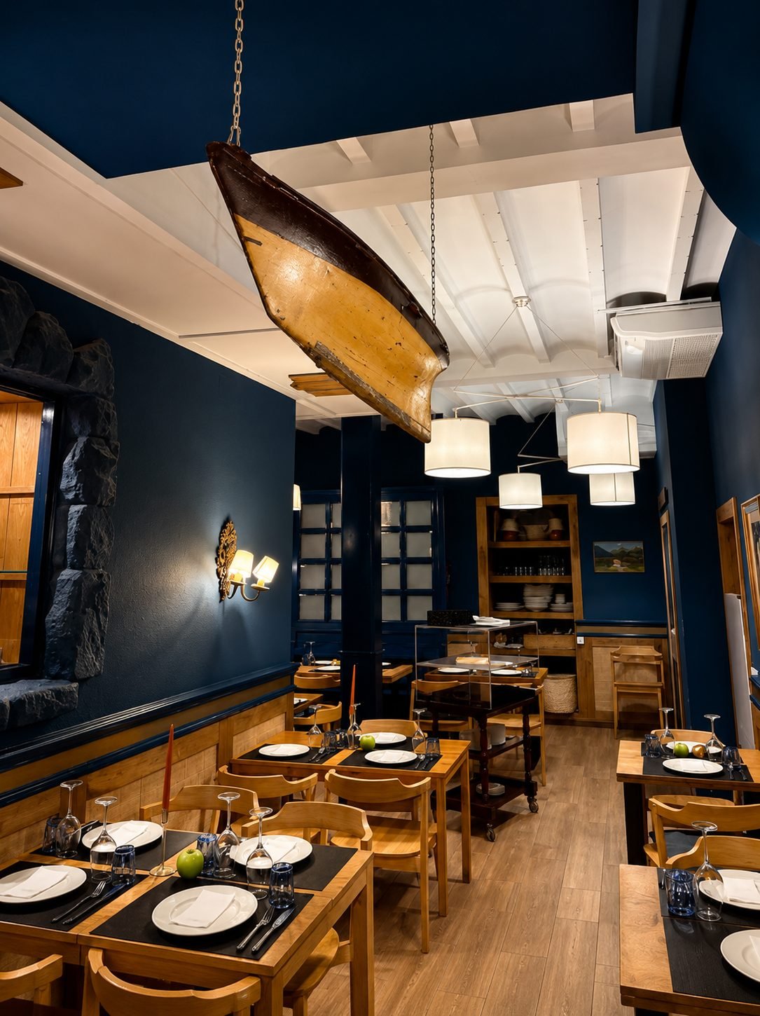 Comedor azul de El Rubio con una barca colgada del techo
