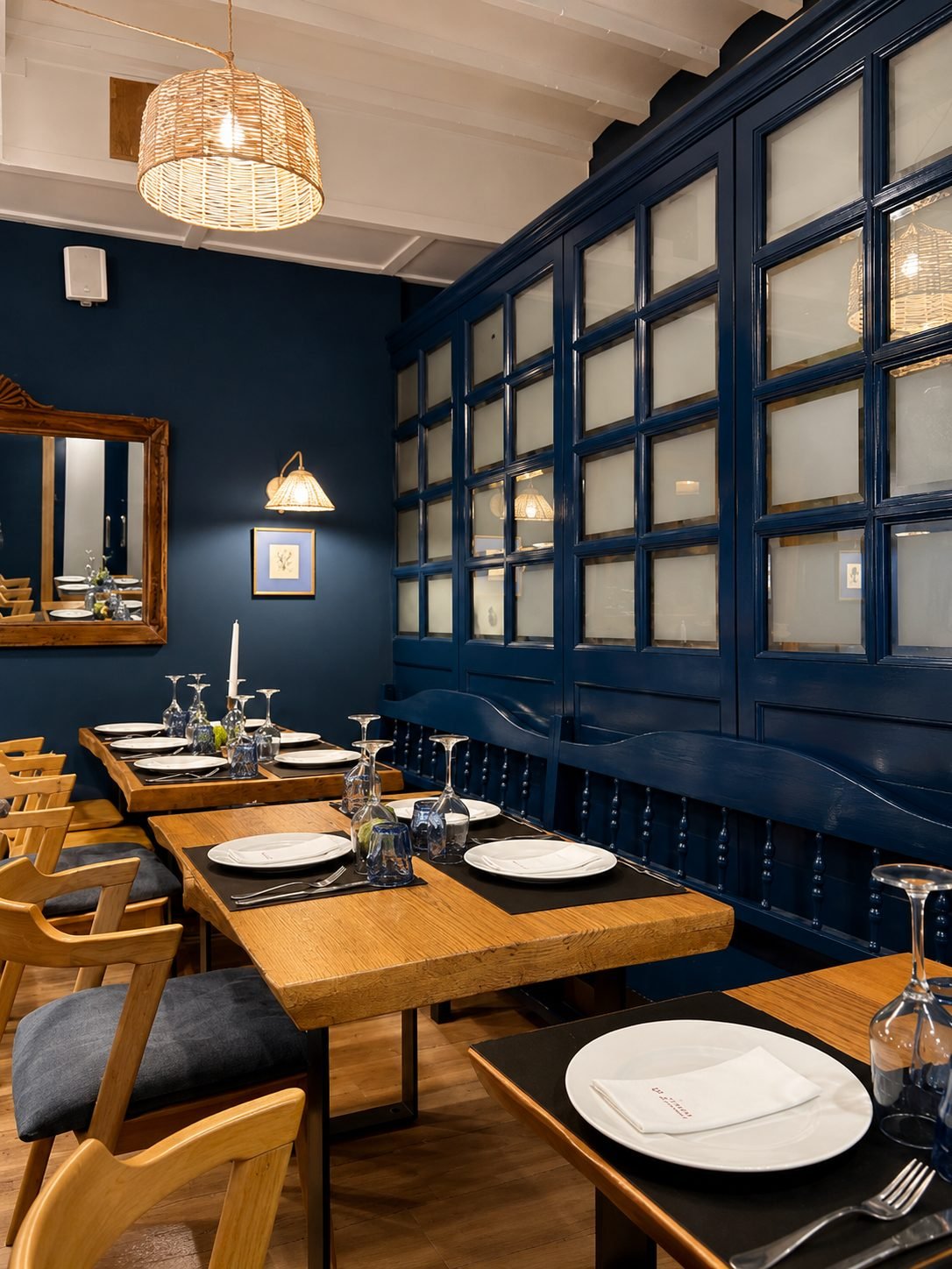 Comedor de El Rubio con mamparas acristaladas y mesas de madera