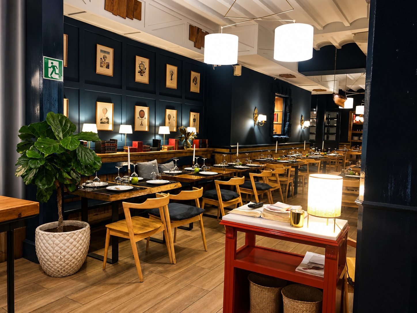 Comedor de El Rubio con paredes azul petróleo, láminas enmarcadas y lámparas de luz cálida