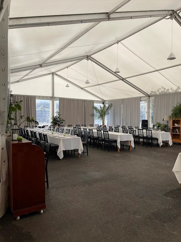 Carpa para eventos del S-20 con mesas largas vestidas de blanco