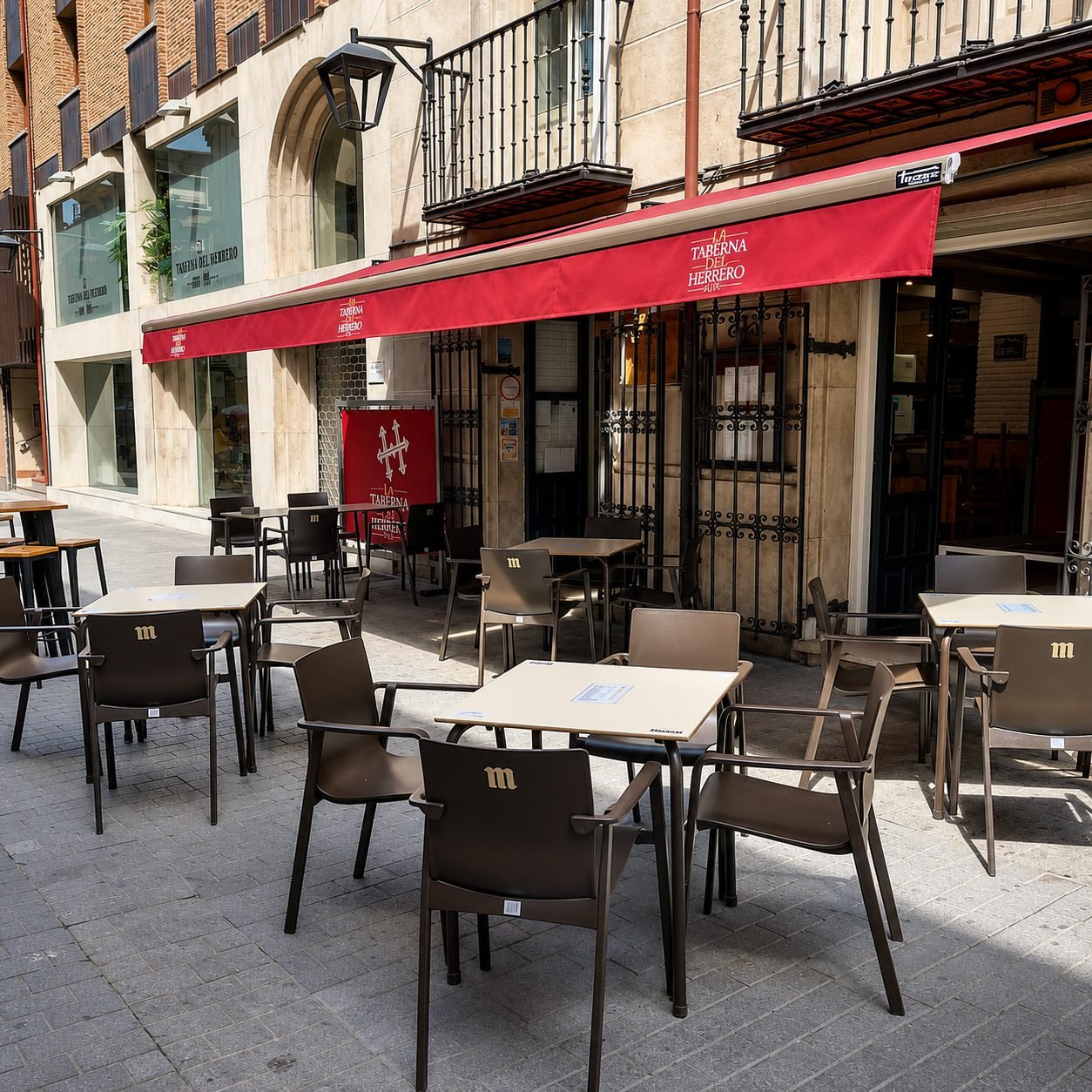 Terraza con toldo rojo de la taberna de Valladolid en calle peatonal